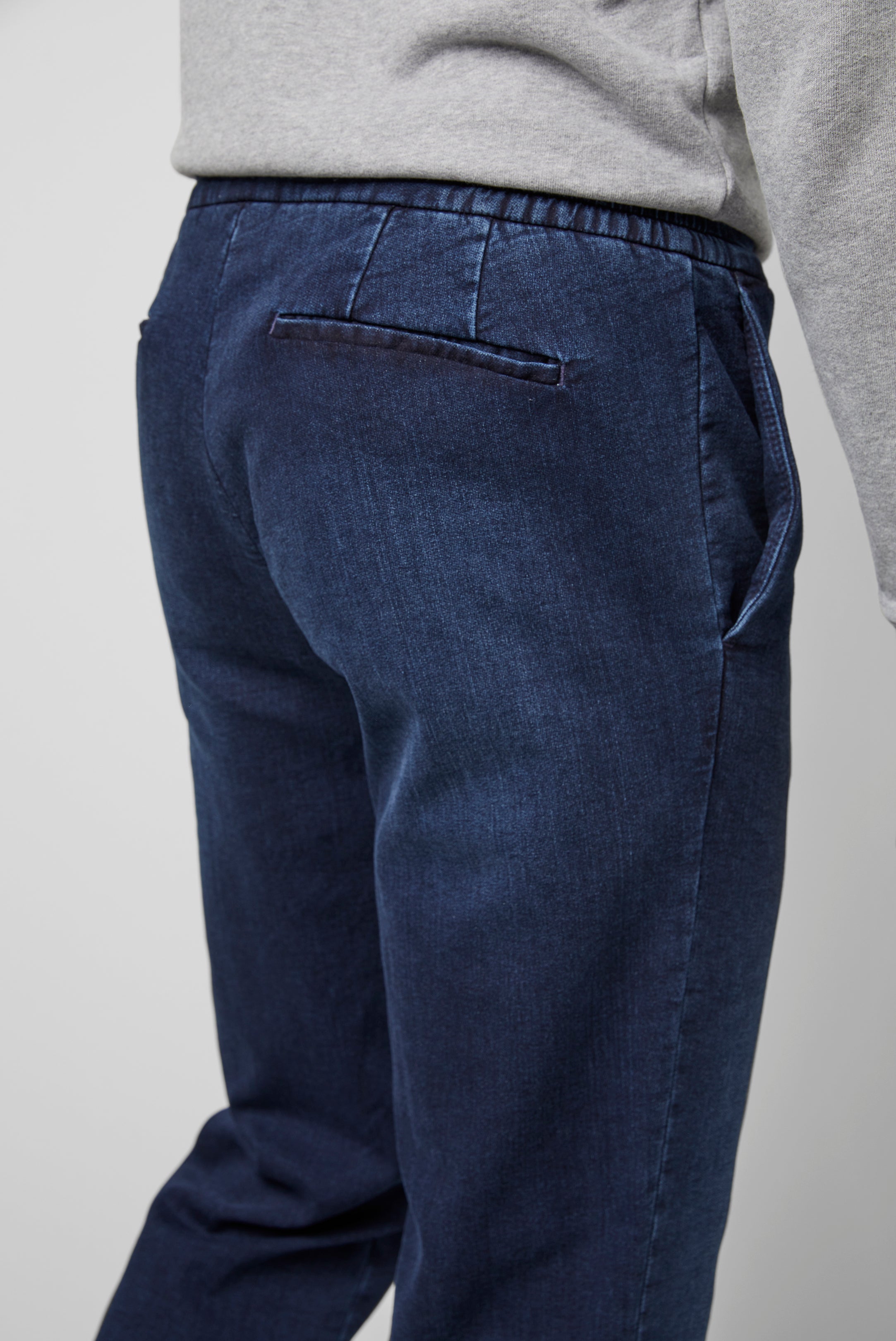 Blue pants worn by a person on a plain background